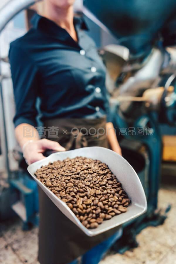 咖啡师女士,配上新鲜烘焙的咖啡豆样品